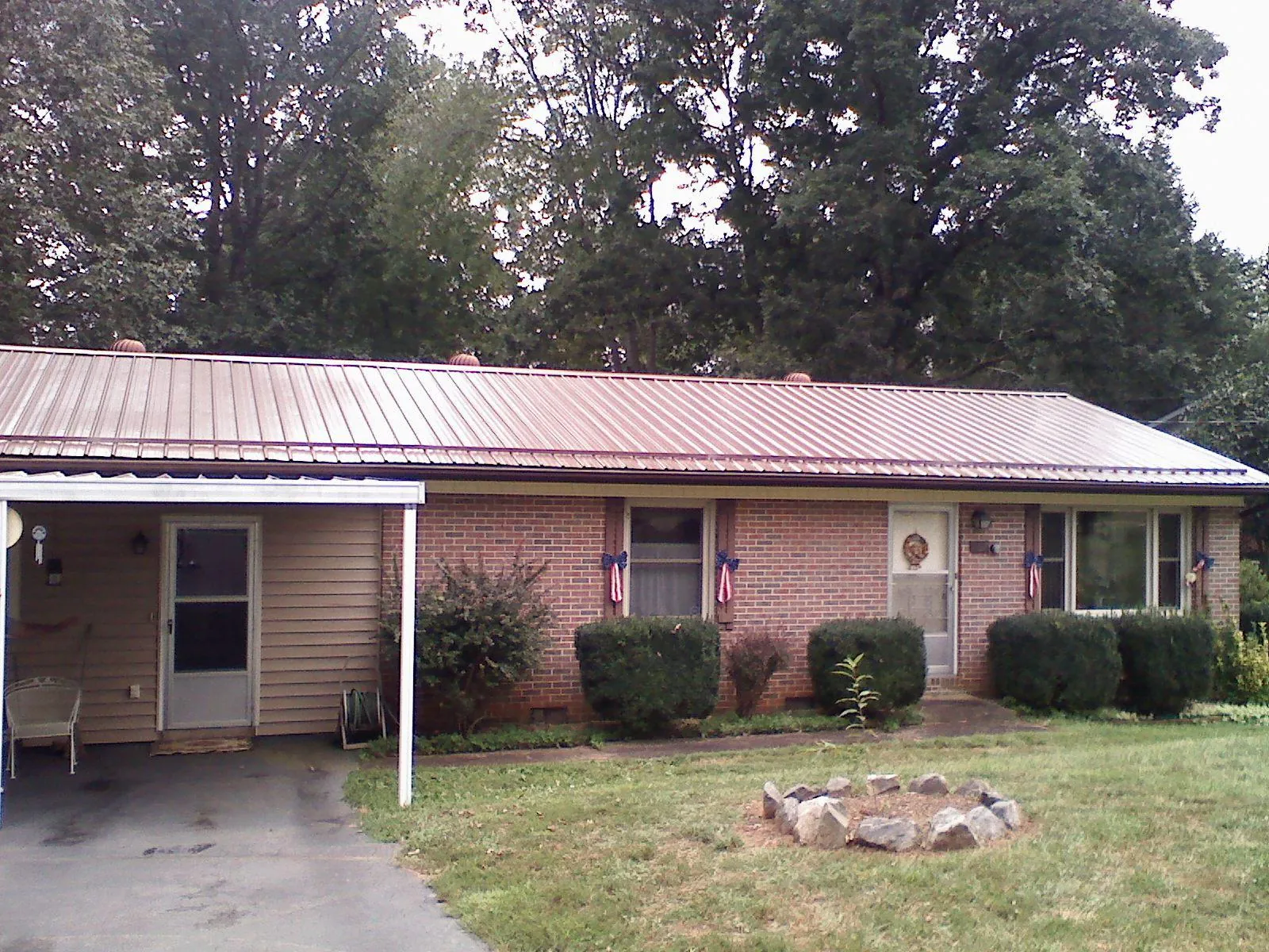 Bronze metal roof and carport on a brick ranch home — Roof Repair work by our crew in Junction City